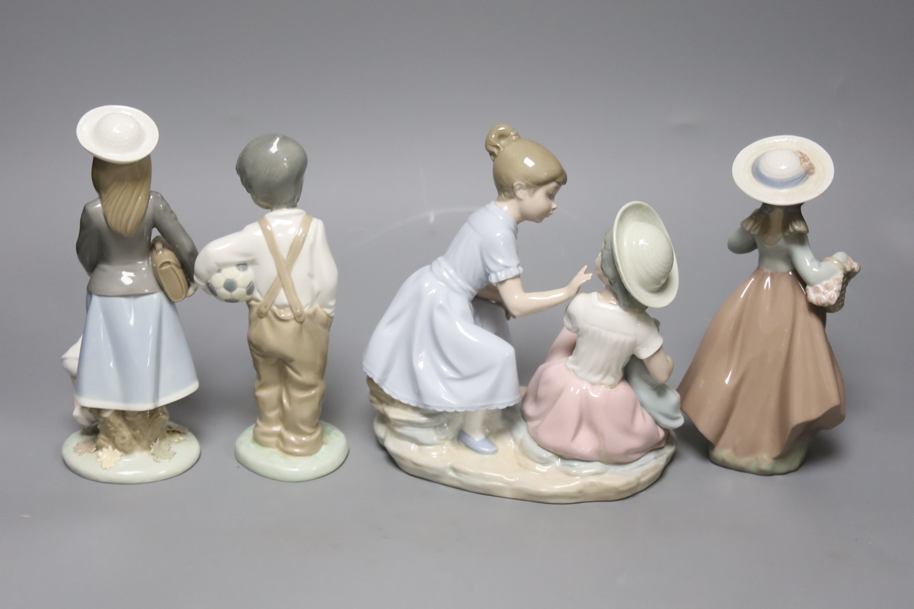 A Lladro figure, height 20cm, and three Nao figures